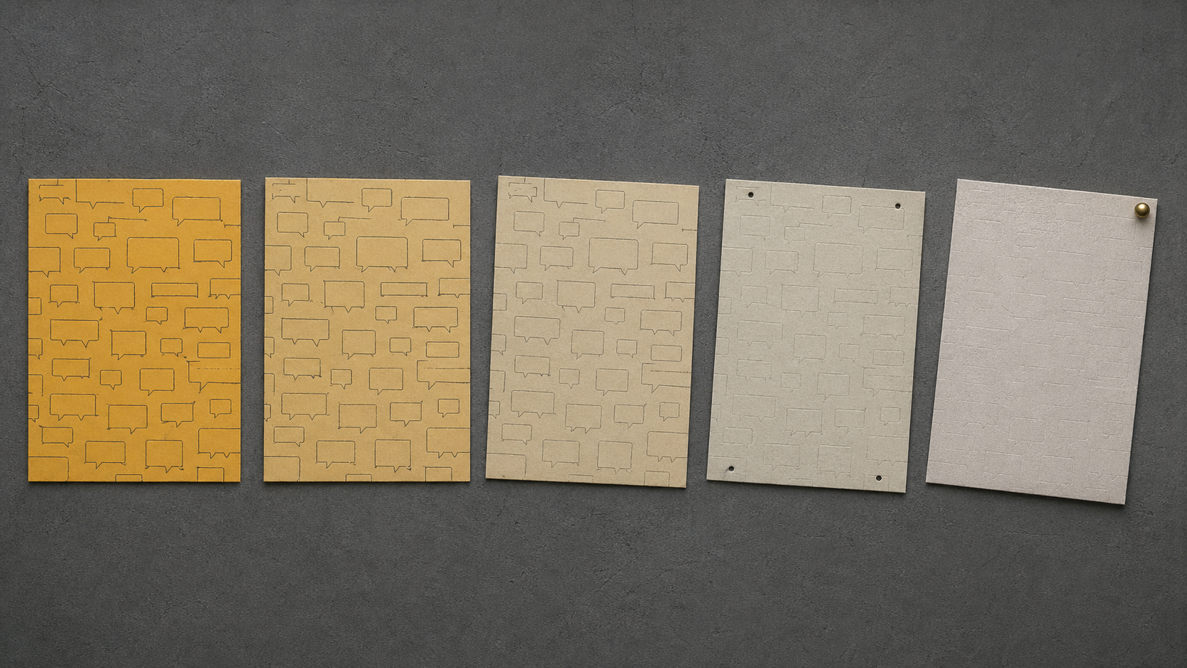 Wall-mounted row of five cardstock panels fading from saturated amber to pale grey, the last panel hanging from a single pin at an angle.