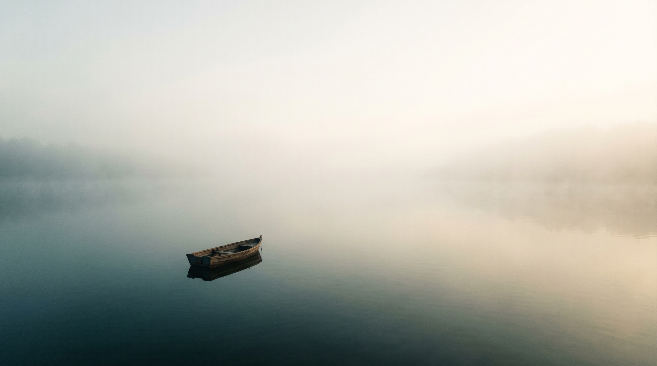 A single rowboat alone on glassy water in dawn fog, with vast empty space around it — illustrating how subtractive design lets a small focused scene carry an entire game.
